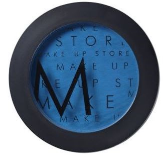 En rund klokke med blå skjerm, svart ram og svarte visere, med ordene 'MAKE UP' gjentatte ganger.