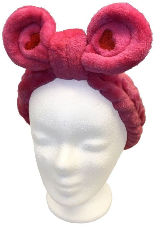 Ett rosa plyschhårband med stora musöron, visat på ett vitt huvud av skumgummi.