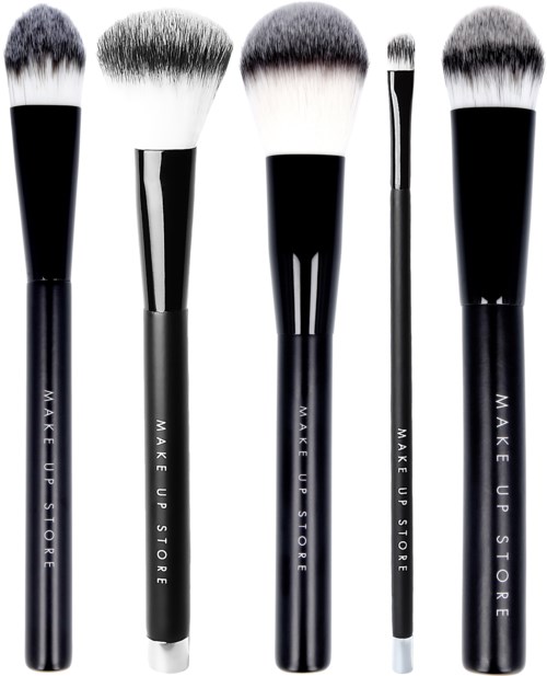 Fem makeupborstar i olika storlekar och former, alla svarta handtag med vit text, med fluffiga borsttoppar.