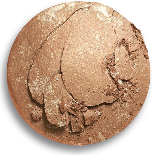 Ett pressat, sprucket pudermakeup i ljusbrunt färg, med några vita fläckar på toppen.