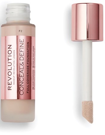 En foundationsflaske med rosa lokk og svampapplikator, merket 'Revolution Conceal & Define Full Cover Foundation.'