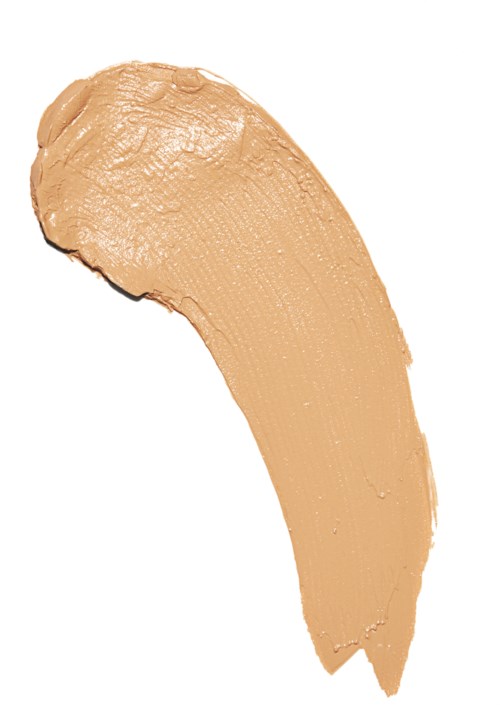 Ett beige sminkstift med kurvad form och texturerad yta.
