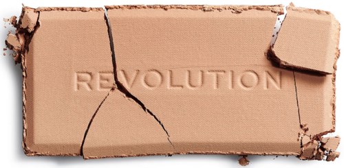 Ett trasigt beige tegel med ordet 'REVOLUTION' inristat i det, sprickor går igenom tegelstenen.