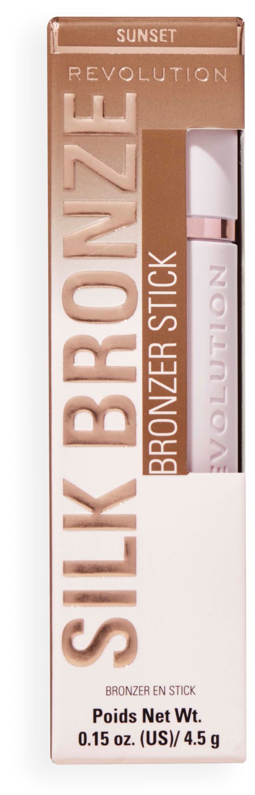 En låda med Revolution Silk Bronzel stick med vit och rosa design, visar produkten inuti. Innehåller 0,15 oz.