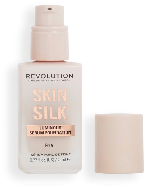 Eine weiße Flüssigfoundation-Flasche mit Pumpe und separatem Deckel, gekennzeichnet 'Revolution Skin Silk Luminous Serum Foundation'.
