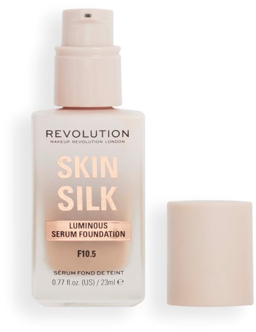 Eine weiße Flasche mit einem Pumpenverschluss, beschriftet mit 'Revolution Skin Silk Luminous Serum Foundation,' und ein Deckel daneben.