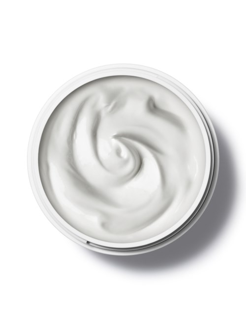 Een ronde bak met witte room, gesponnen in het midden, op een witte achtergrond.
