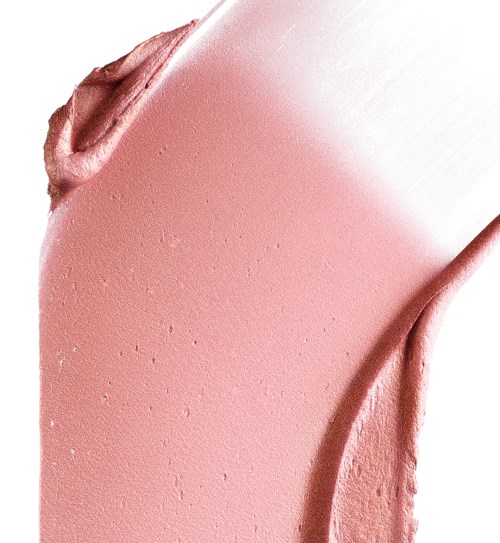 Rosa makeupkräm utbredd på vit bakgrund, visar slät och krämig textur.