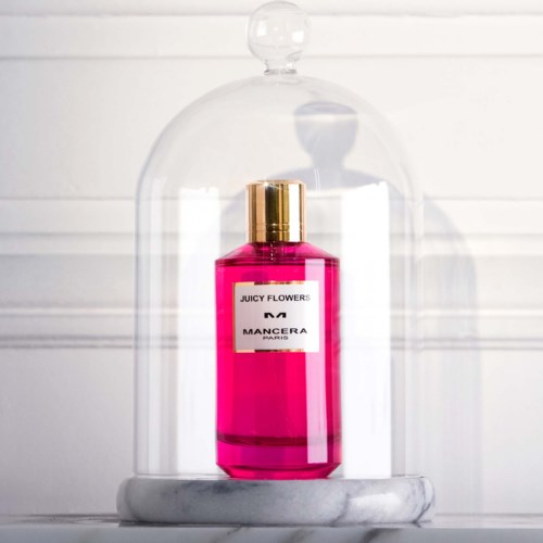 En pink parfume flaske med guldhætter i en glastype og marmorbund.