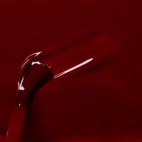 A shiny red paintbrush touches a red surface, creating a stroke. The background is also red, blending seamlessly.