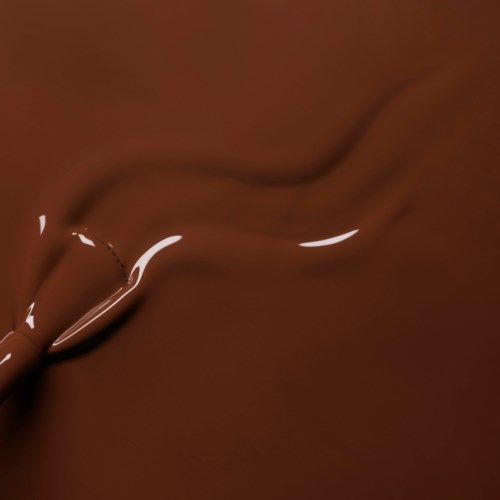 A stream of melted chocolate being poured and flowing smoothly.