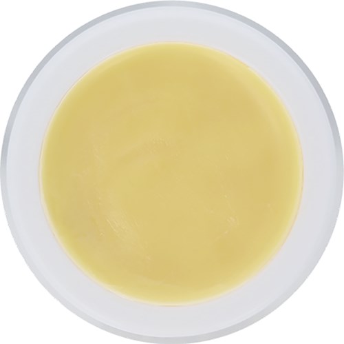 En skål med gul væske, sannsynligvis suppe eller saus, sett ovenfra.