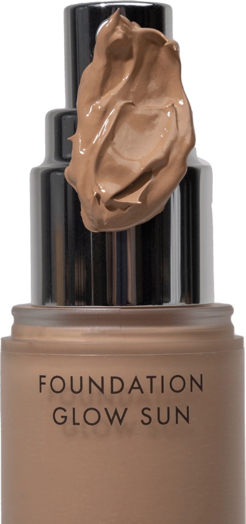 En foundationflaska med en virvla av makeup ovanpå och en glänsande svart kork.