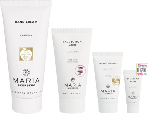 Four skincare products in white tubes with black text, including hand cream, face lotion, papaya peeling, and eye cream.