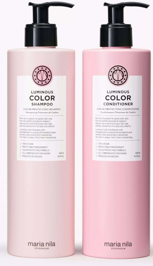 Två rosa flaskor för hårvård, en för schampo och en för balsam, med svarta pumpkorkar och vita etiketter.