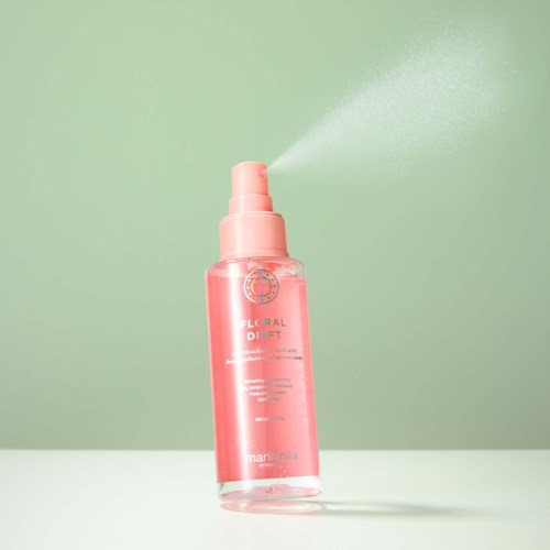 Rote Sprayflasche mit Dunst vor grünem Hintergrund. Sie ist beschriftet Floral Drift von Marini Nila.