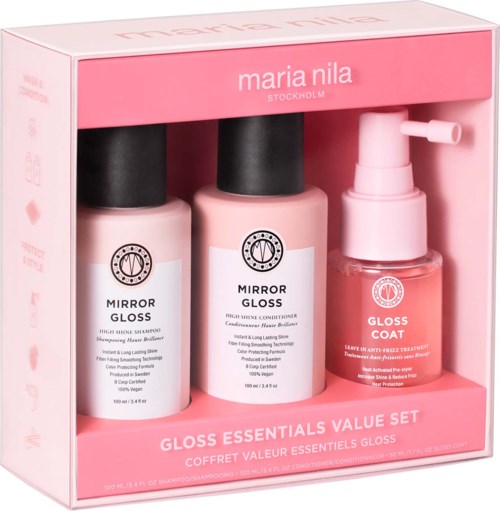Ett rosa skönhetsproduktset med två flaskor av hårglans och en liten sprayflaska, allt i en box.