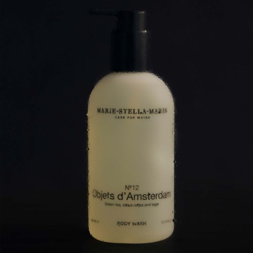 Cream-colored body wash bottle with black cap, labeled as Marie-Stella-Maris, Objects d'Amsterdam, and No. 12.