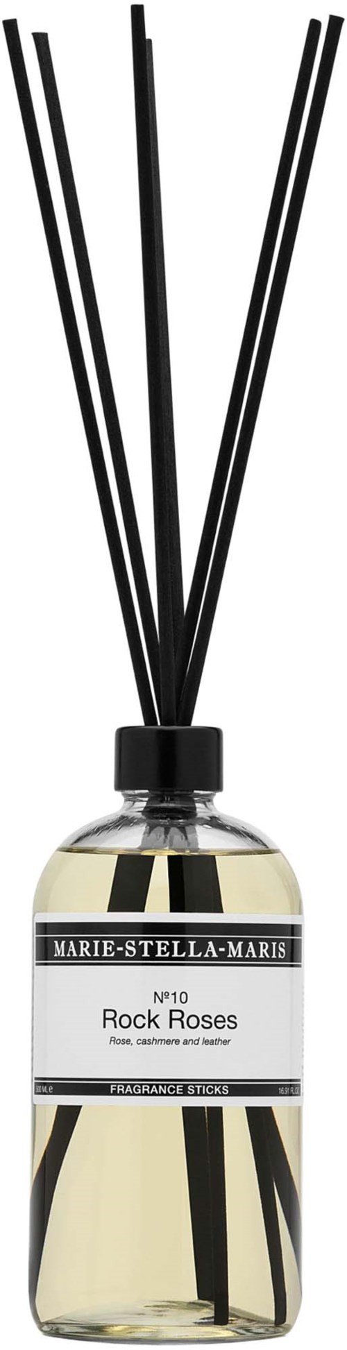 A glass bottle with black sticks inside and a label that reads Marie-Stella-Maris Rock Roses.