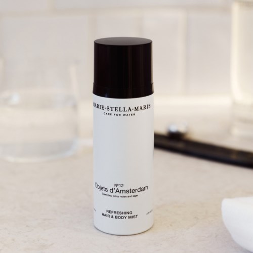 A white and black bottle labeled Marie-Stella-Maris, with text about water care and refreshing hair and body mist.