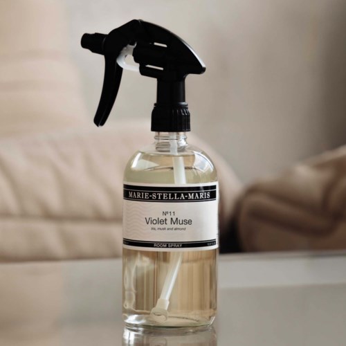 En genomskinlig sprayflaska med svart munstycke innehåller en rumsdoft med etiketten Marie-Stella-Maris Violet Muse.