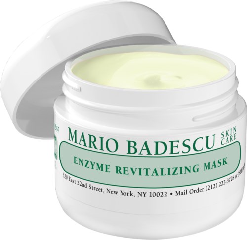 En hvit krukke med ansiktsmaske, med åpen lokk, merket 'Mario Badescu Enzyme Revitalizing Mask,' med krem inni.