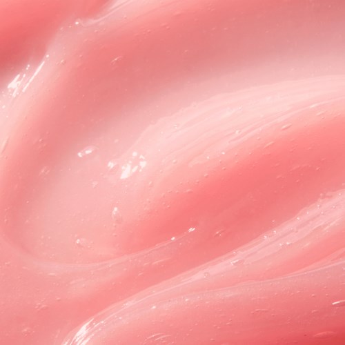 En närbild av en rosa, slät och glänsande yta med lena kurvor och ljusreflektioner.