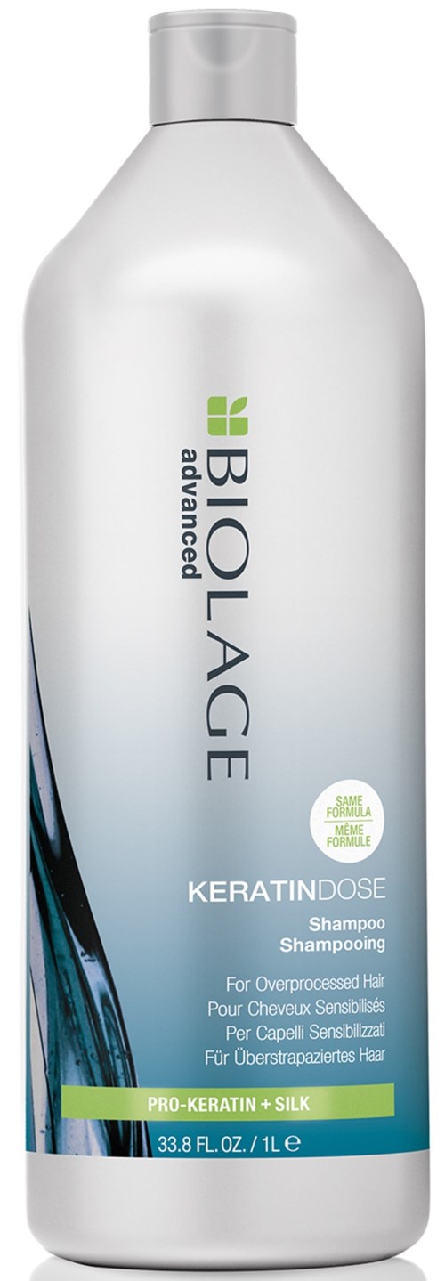 En vit schampo-flaska märkt 'Biolage Advanced KeratinDose' med gröna och blå accenter och text för hårvård.