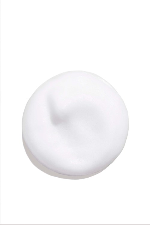 A dollop of white cream or lotion on a white background. It looks smooth and soft.