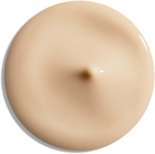 Een ronde, beige voorwerp met een klein punt in het midden, glanzend oppervlak en lichte schaduw.