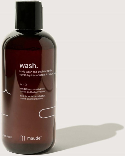 En mörkbrun flaska märkt 'wash' med svart lock, innehållande kroppstvål och bubbelbad. Enkel design, mjukt skuggande.