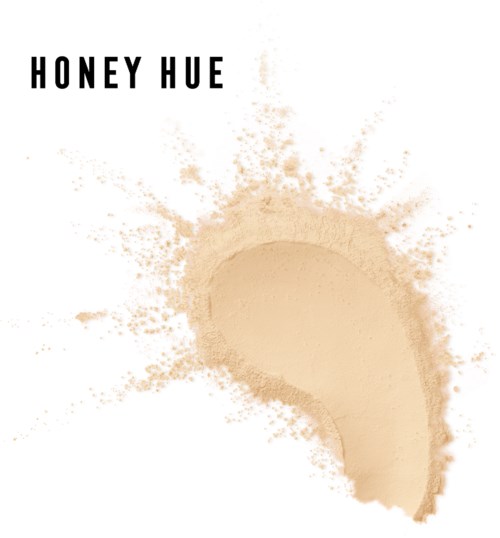 En stänk av ljus beige pulver med en böjd form och orden "HONEY HUE" ovanpå.