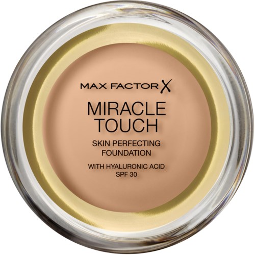 En rund foundation-glasskål merket 'Max Factor Miracle Touch' med hudfarget farge på midten. Den nevner hyaluronsyre og SPF 30.
