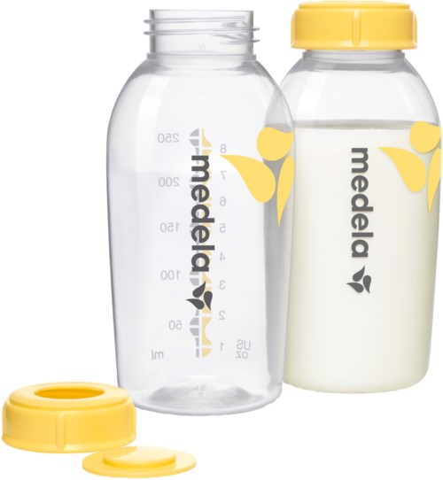 Two breast milk bottles, one clear and one filled with milk, both labeled 'medela' with yellow caps and leaf designs.