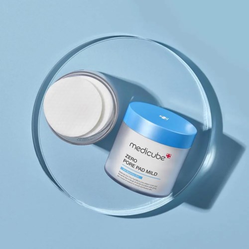 En boks med medicube Zero Pore Pad Mild på en klar rund skål, med blå lokk og hvit kropp.