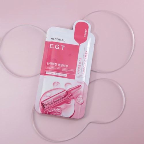A pink and white packet of Mediheal E.G.T ampoule mask with three transparent gel patches.