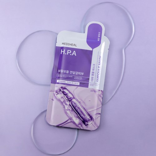 A purple and white facial mask package with a serum vial illustration, surrounded by heart-shaped cutouts.