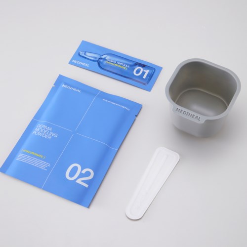 Medicinsk hudvårdsproduktset innehåller en blå påse, en liten kopp, en spatula och en tub.