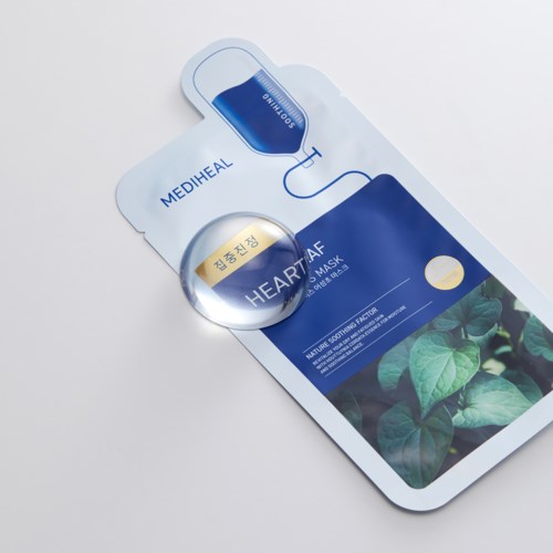 Een gezichtsmasker met groene bladeren en huidpleister, gemerkt Mediheal Heart Leaf, waarschijnlijk voor huidverzorging.