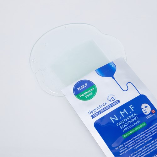 Eine Gesichtsmaskenverpackung zeigt einen Serumdroplet, der auf das Gesicht aufgetragen wird.