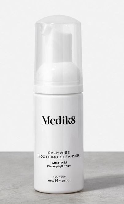 En vit flaska märkt 'Medik8 Calmwise Soothing Cleanser' med pump, avsedd för mild hudrengöring.