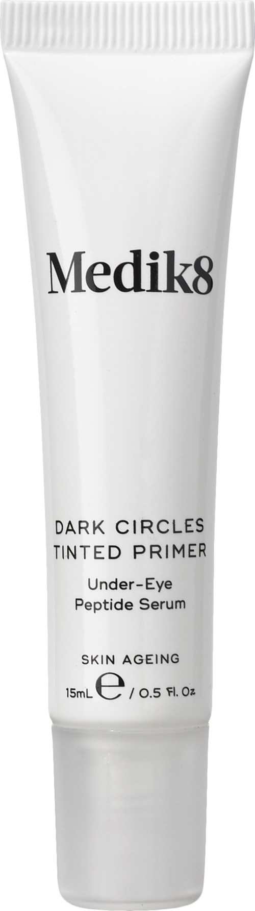 En hvit tube merket Medik8 Dark Circles Tinted Primer, designet for under-øyen for å redusere mørke ringer og aldring av huden.