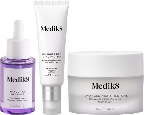 Drei Hautpflegeprodukte in weißen Behältern, darunter Serum, Feuchtigkeitscreme und Nachtcreme von Medik8.