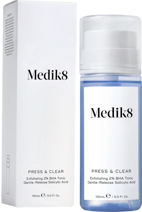Ein weißer Karton und eine klare Flasche mit 'Medik8'-Label, blauer Flüssigkeit. Flasche hat weißen Deckel. Beide sind Hautpflegeprodukte.