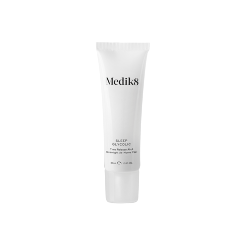 En hvit tube fra Medik8 Sleep Glycolic med svart tekst. Det er et hudpleieprodukt for å hjelpe med søvn og hudfornyelse.