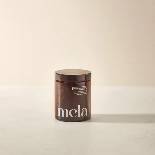 En brun behållare med lock, märkt 'mela' på framsidan, placerad på en vit yta.