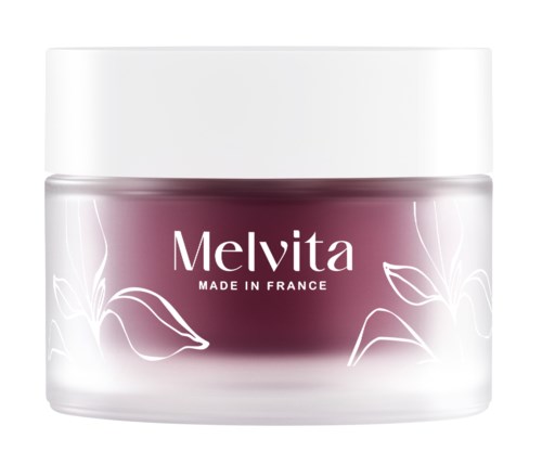 En burk med beauty-kräm med vit bladdesign, etiketten säger 'Melvita MADE IN FRANCE'.