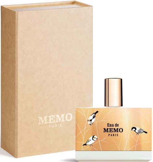 En parfymeflaske med en beige eske bak, med etikett med fugler og ordene 'Eau de MEMO Paris.'