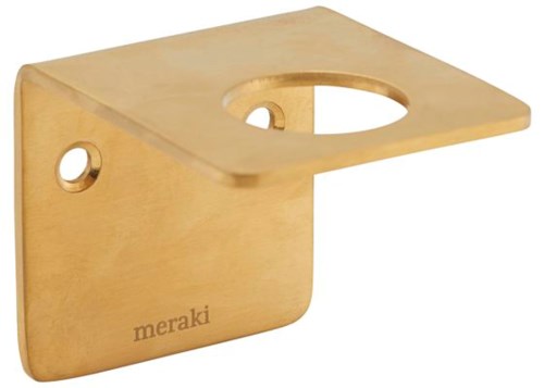 Et guldfarvet metalobjekt med et hul øverst og et i siden, mærket 'meraki' nederst.