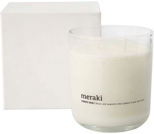 En vit box och ett ljus i en glasbehållare med en etikett som säger 'meraki' och lite liten text.